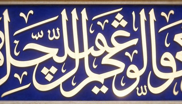 Raised cream arabic calligraphy embossed on cobalt ceramic tile panel with beige trim