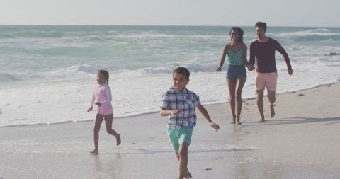 Family Enjoying Day at Sandy Beach by Ocean Waves