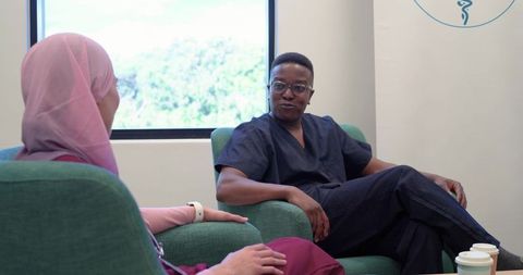 Diverse healthcare professionals discussing patient care in lounge with natural light