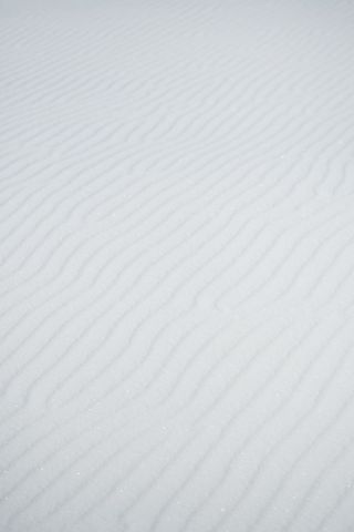 White sand dune ripples minimal abstract texture with sparkling granules and soft lines