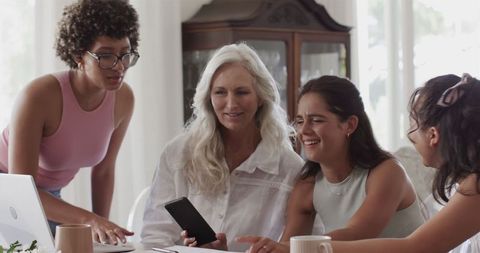 Group of Women Collaborating with Technology at Table