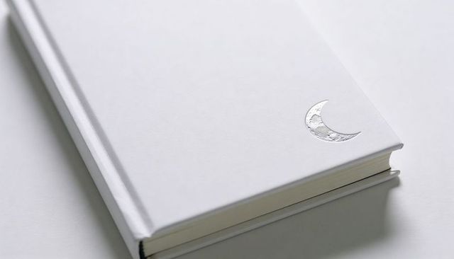 Minimalist white hardcover journal featuring silver crescent moon foil emblem