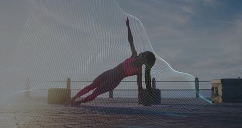 Woman Practicing Side Plank Pose on Pier at Sunrise