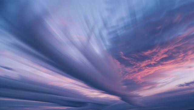 Pastel Clouds Sweeping Across Dusk Sky with Vibrant Colors