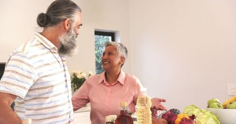 Senior Couple Discussing While Preparing Vegetables Together