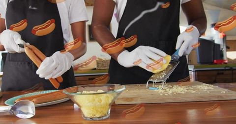 Holding hot dogs and grating cheese at rustic counter showing food prep teamwork