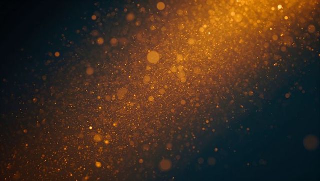 Golden dust particles in radiant amber light