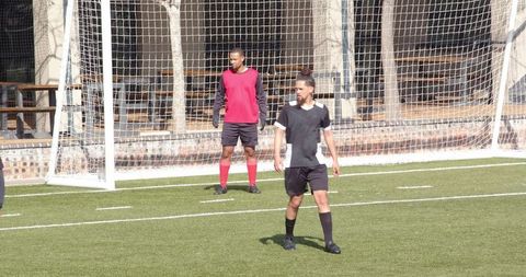 Soccer Player Practicing on Field in Black Uniform
