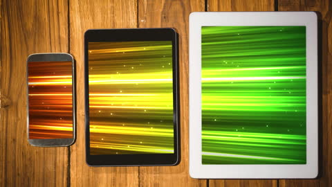 Smartphone and Tablets on Wooden Background Displaying Animated Graphics