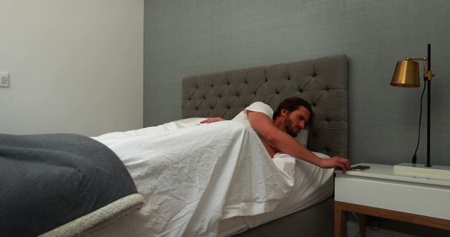 Man waking up in bed and checking smartphone - Download Free Stock Images Pikwizard.com