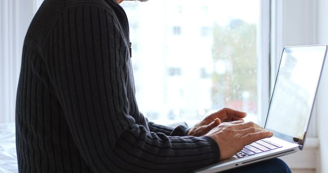 Man Working Remotely on Laptop by Window - Download Free Stock Images Pikwizard.com