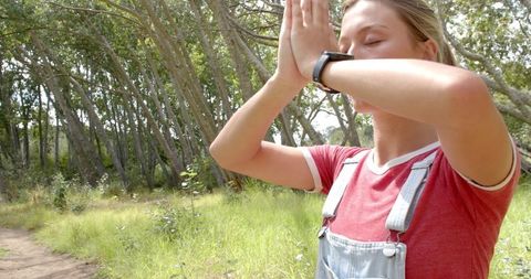 Young Woman Exploring Nature with Binoculars in Lush Forest