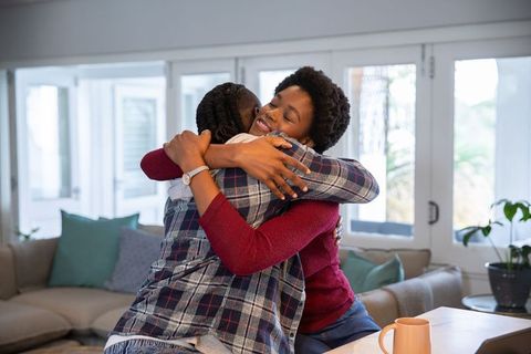 Mother and Daughter Embracing in Cozy Living Room