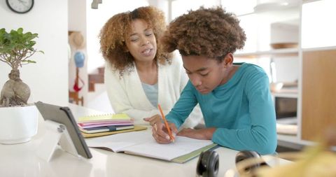 Mother Assisting Son with Homework in Modern Kitchen