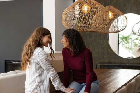 Female Partners Smiling and Unpacking in Modern Home