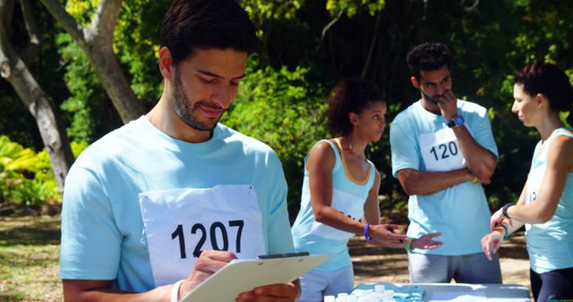 Volunteers Preparing for Outdoor Marathon with Registration Forms - Download Free Stock Images Pikwizard.com