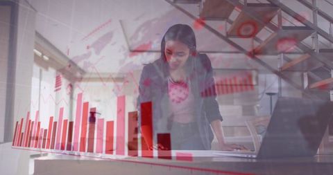 Businesswoman analyzing data projections on laptop