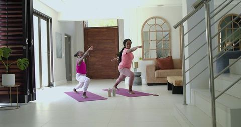 African american mother and daughter practicing yoga and home workout together