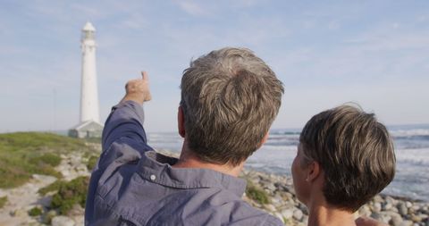 Senior Couple Enjoying Coastal Visit Near Lighthouse