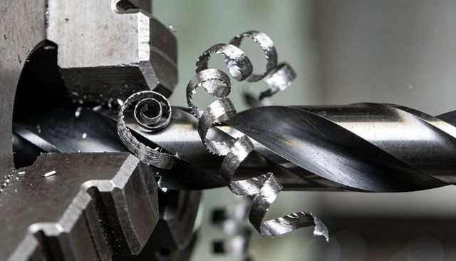 Twist drill cutting steel producing curled swarf with serrated 3-jaw chuck