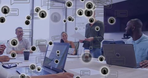 Female leader presenting in collaborative boardroom with laptops and digital chat overlays