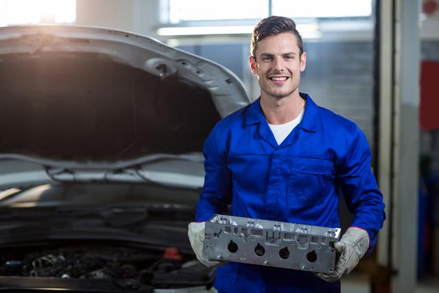Mechanic holding car parts in repair garage