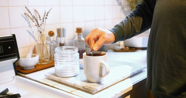 Person Stirring Coffee in Cozy Kitchen Setting - Download Free Stock Images Pikwizard.com