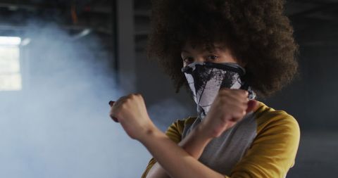 Afro woman wearing face mask making stop gesture in parking garage