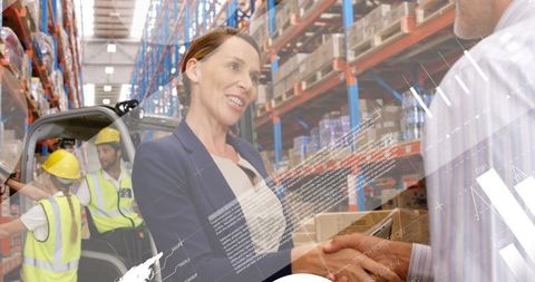 Businesswoman Shaking Hands with Partner in Warehouse