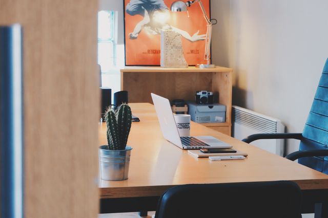 Modern home office with sleek desk, laptop, and cactus plant creates ideal productivity environment for remote work, design inspiration, or blog posts.