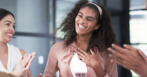 Diverse colleagues celebrating with awards in office