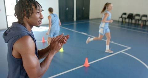 Motivational coach encouraging players during indoor drill