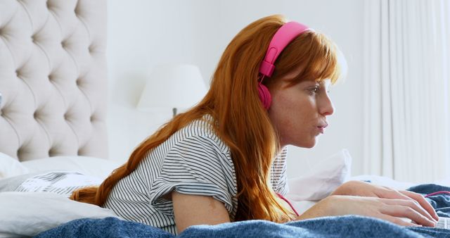Beautiful woman listening music while using laptop in bedroom 4k - Download Free Stock Photos Pikwizard.com