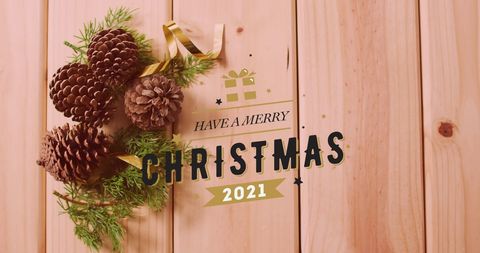 Vintage Christmas Greeting with Pine Cones on Wooden Background