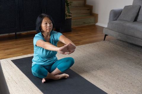 Middle-Aged Woman Practicing Yoga at Home for Fitness and Relaxation
