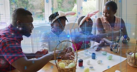 Family decorating easter eggs wearing bunny ears with futuristic digital overlay