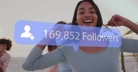 Smiling Woman Celebrates Social Media Followers on Beach