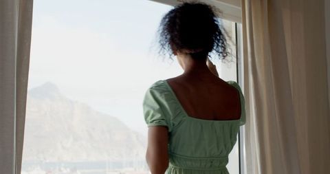 Woman enjoying scenic coastal view from hotel window