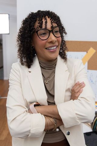 Confident african american creative director smiling in modern studio wearing beige blazer