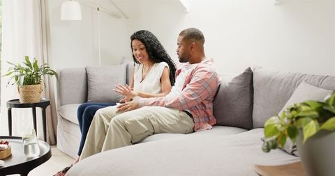 Engaged Couple Sharing Joyful Moment on Smartphone at Home