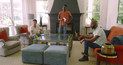 Casual gathering of friends relaxing at home with drinks