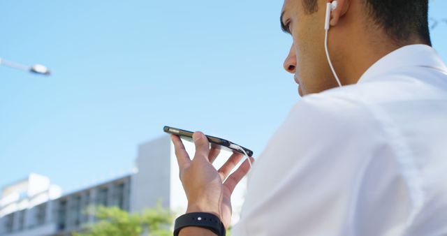 Young Male Professional Talking on Smartphone with Earphones - Download Free Stock Images Pikwizard.com