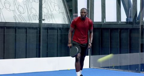 Energetic Man Playing Padel on Vibrant Turf Court