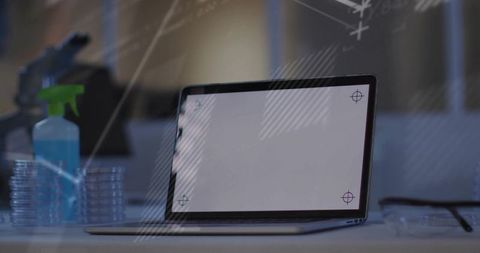Laptop with screen crosshairs in laboratory workspace petri dishes spray bottle safety glasses