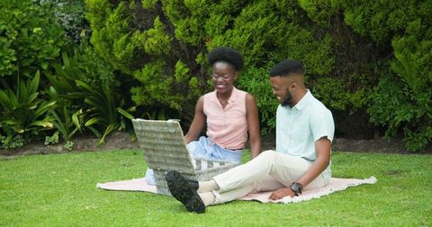 Joyful Couple Enjoying Picnic Time in Lush Park Setting