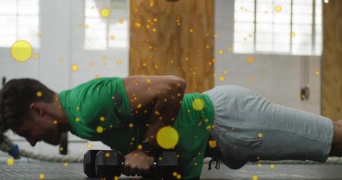Mid-adult man performing dumbbell plank building core strength, balance and stability