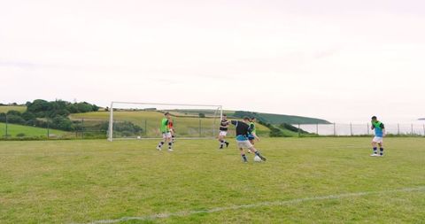 Diverse Soccer Team Playing on Coastal Outdoor Field