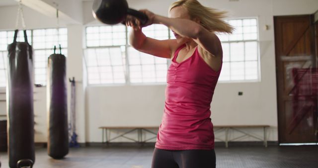 Fit caucasian woman working out with kettle bell at the gym. sports, training and fitness concept