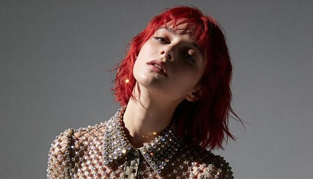 Redhead model tilting head wearing rhinestone mesh top with jeweled collar portrait