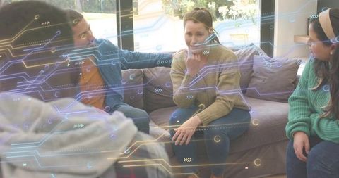 Friends consoling woman on sofa with neon circuit augmented reality overlay, cozy home